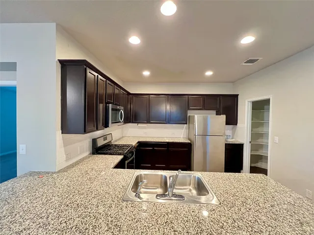 a kitchen with a refrigerator and a sink