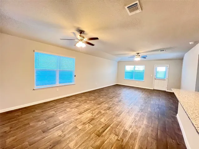 a view of kitchen with kitchen island a sink wooden floor and a refrigerator