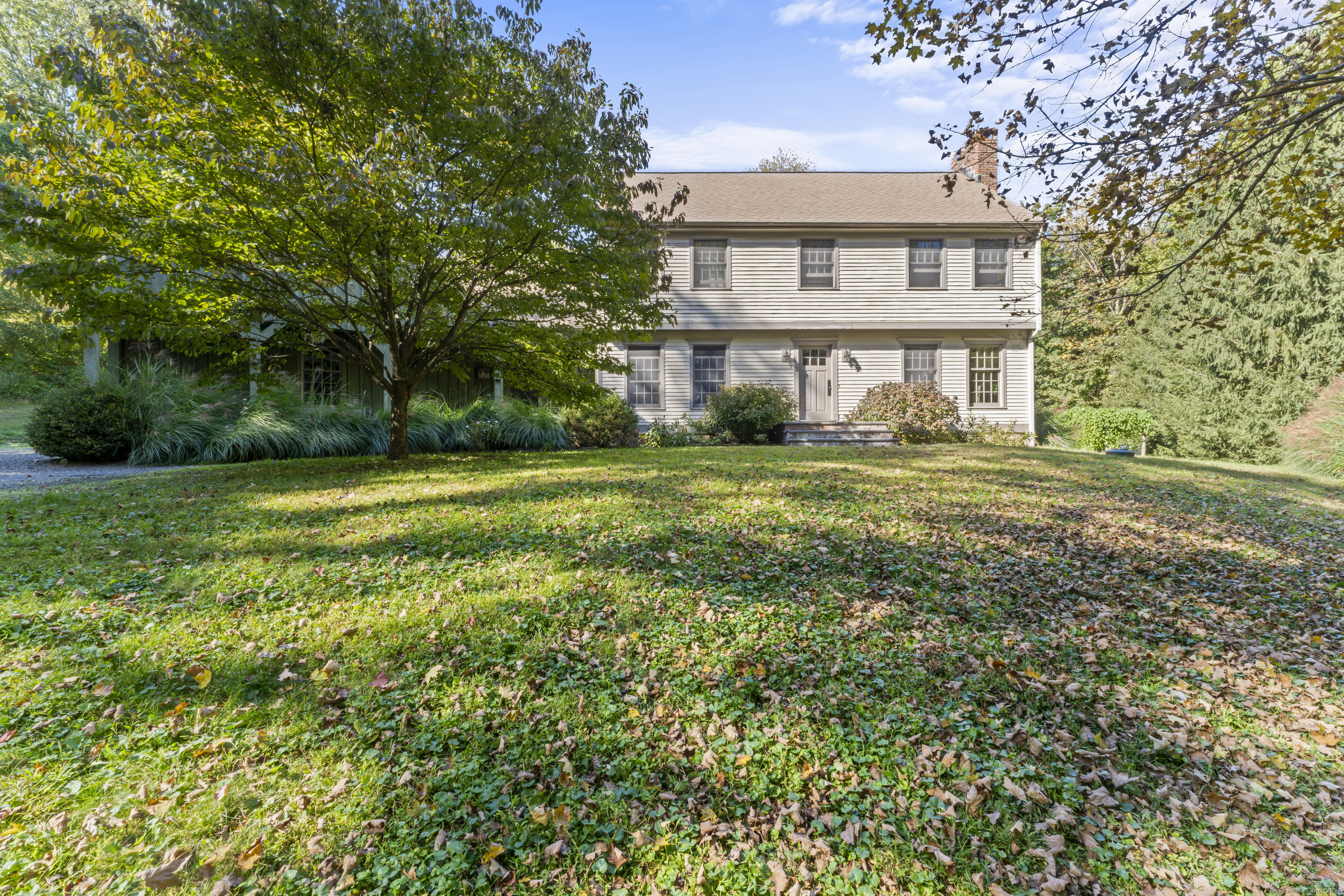 a view of a big house with a big yard and large trees