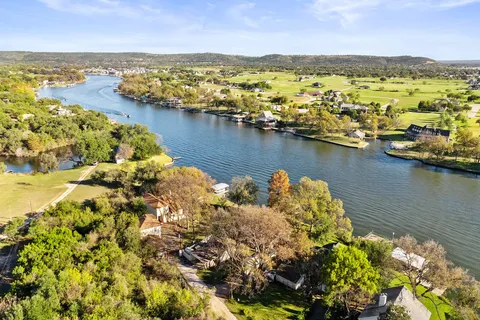 an aerial view of ocean and residential houses with outdoor space
