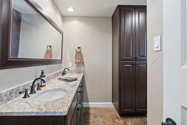 a bathroom with a granite countertop sink and a mirror