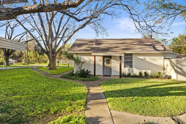 a view of a house with garden and trees