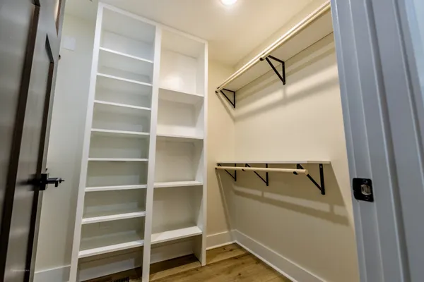a view of walk in closet with empty racks