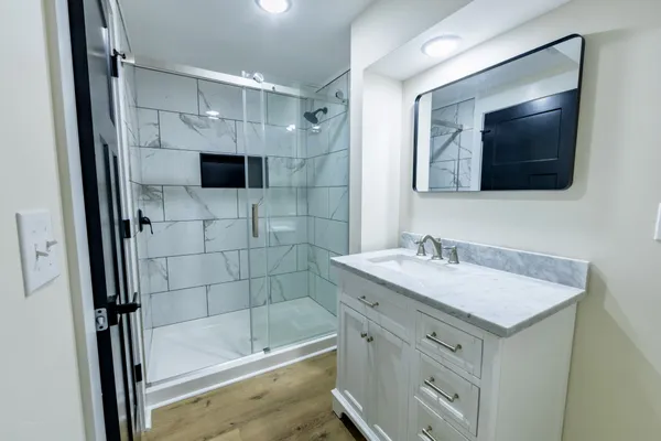 a bathroom with a sink a large mirror and shower