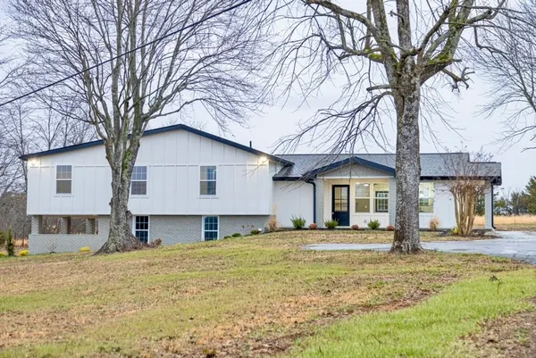 a front view of a house with a yard covered in snow
