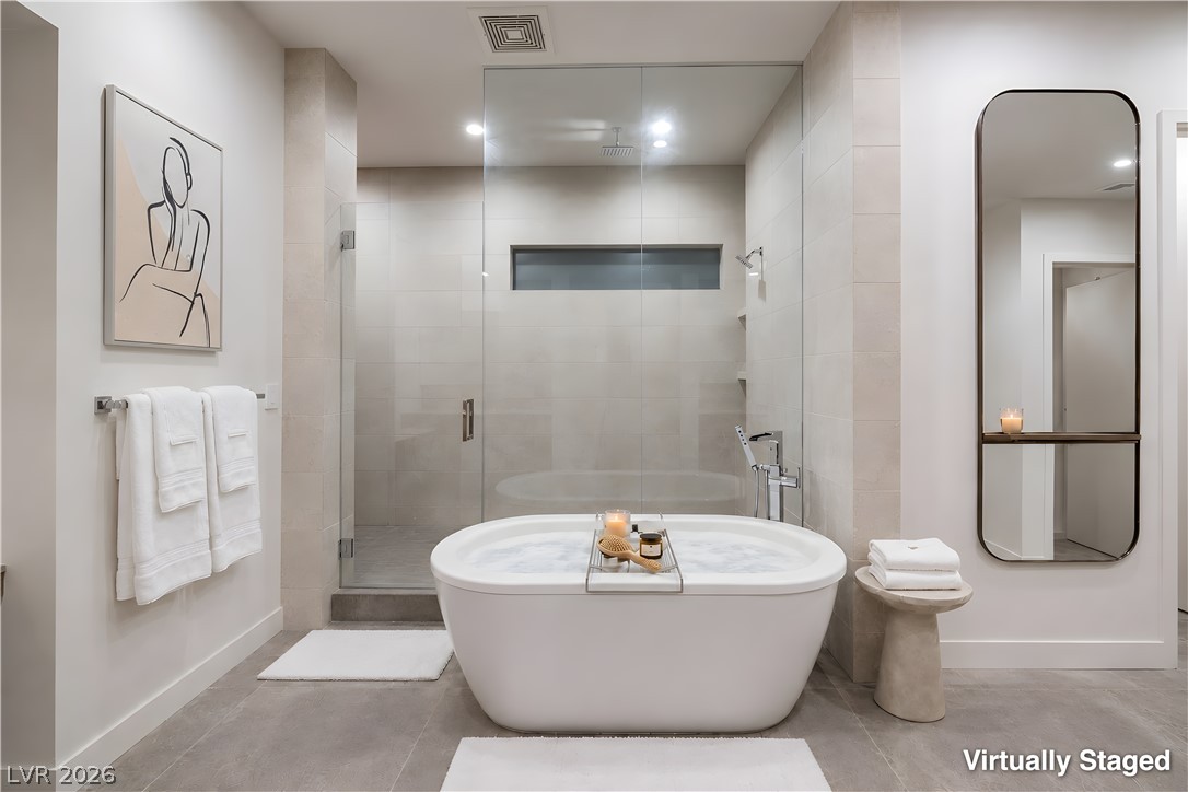 25 Falling Ridge Lane Henderson, NV 89011 - Photo 18 of 48 Luxurious bathing area features a deep soaking tub and a sleek, glass-enclosed shower.