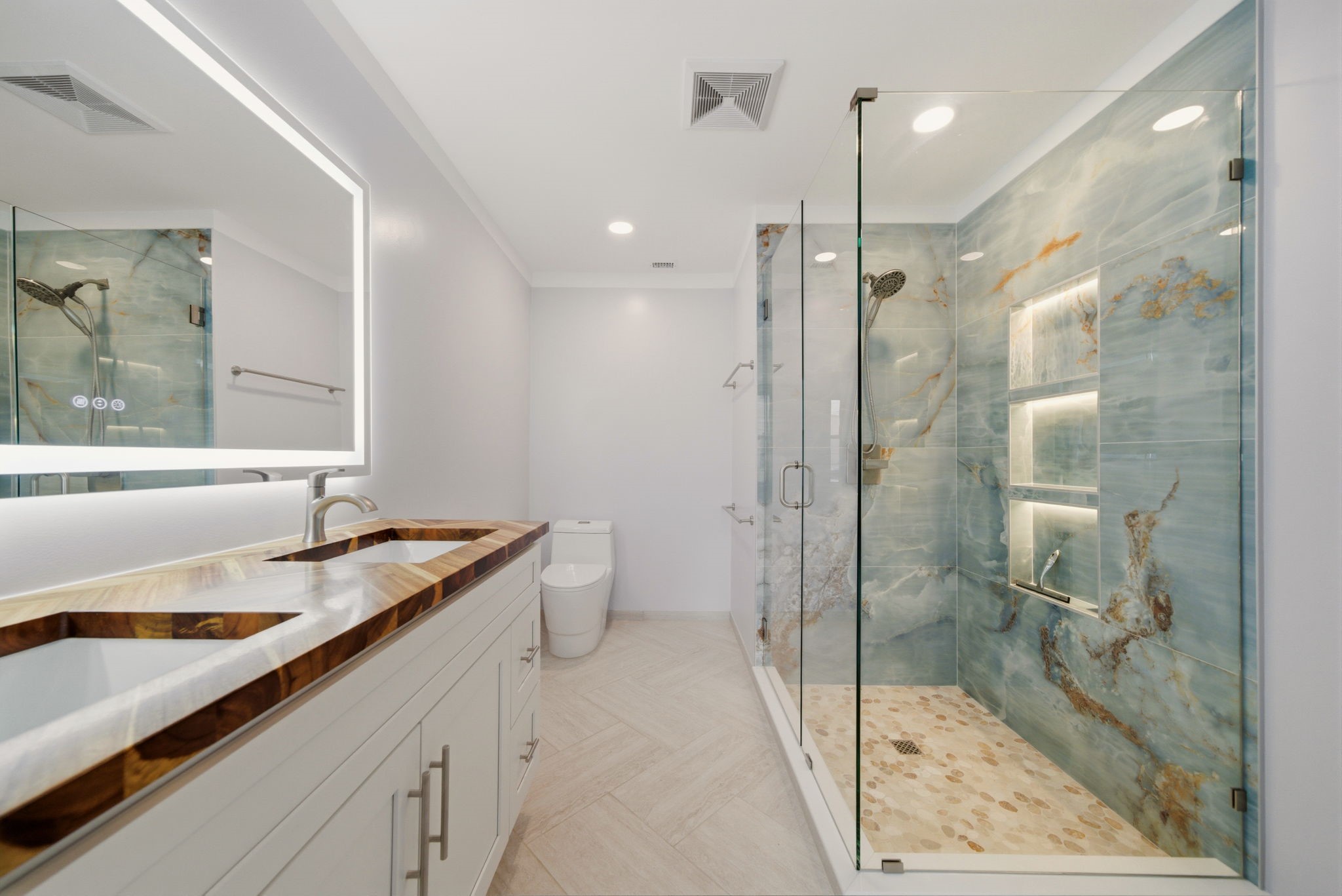 6452 Burgoyne Road, Unit 100 Houston, TX 77057 - Photo 24 of 44 a bathroom with a granite countertop sink a toilet a mirror and shower