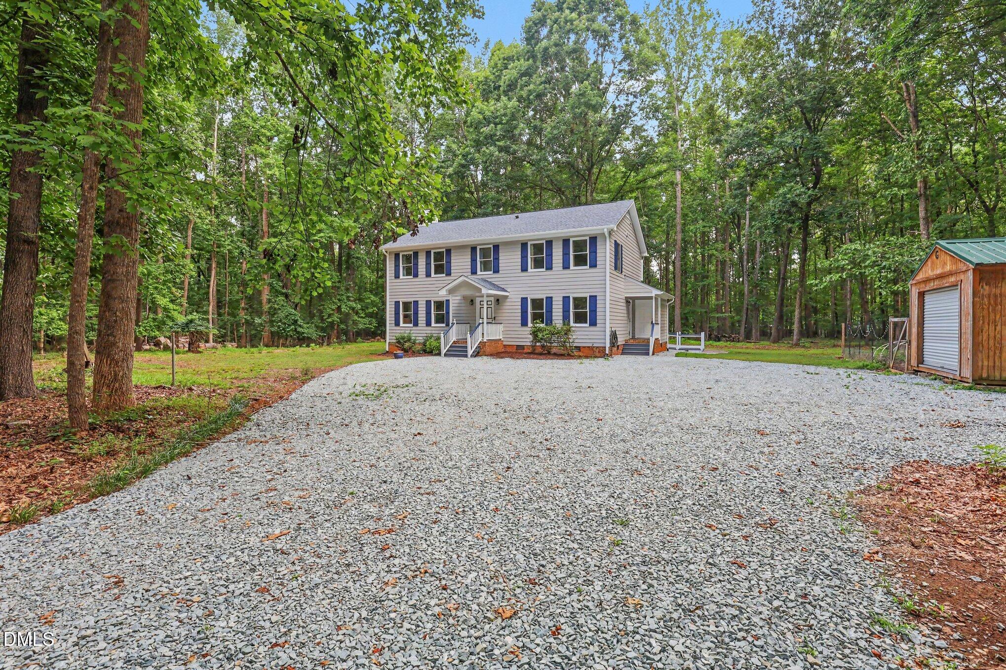 114 Oak Hollow Road Timberlake, NC 27583 - Photo 4 of 31 Two-story residence featuring light-colored siding, blue shutters, and a covered front porch with white railings