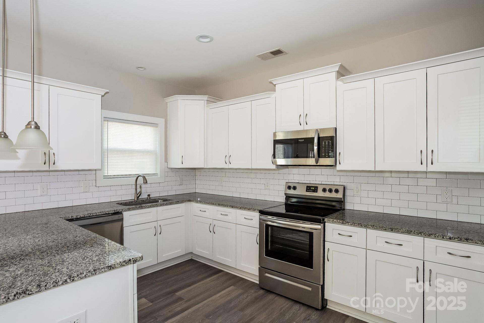 335 Todd Road Charlotte, NC 28208 - Photo 5 of 15 a kitchen with white cabinets stainless steel appliances and sink