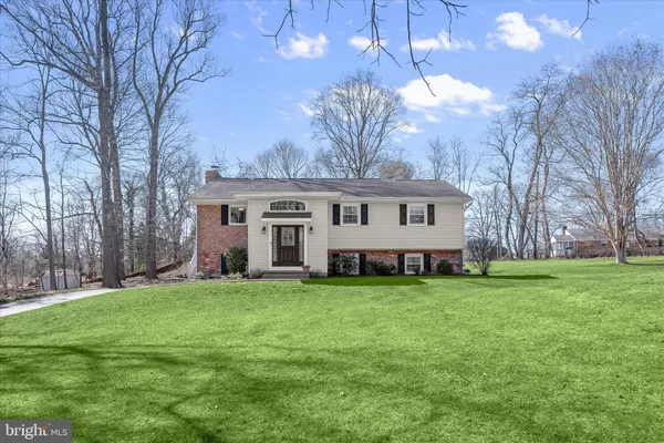 a view of a house with a big yard and large trees