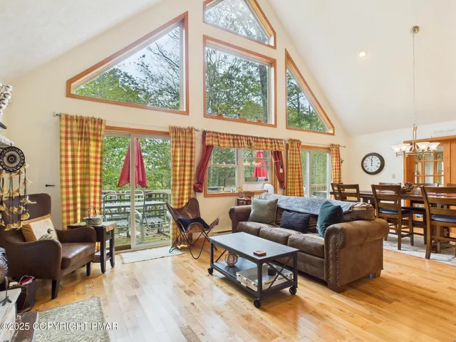 a living room with furniture and floor to ceiling windows