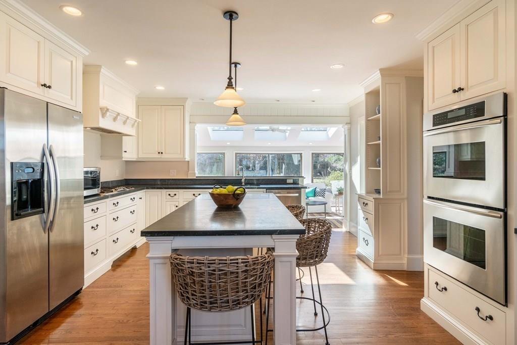 43 Burditt Avenue Hingham, MA 02043 - Photo 12 of 41 a kitchen with stainless steel appliances kitchen island granite countertop a refrigerator a oven a sink and white cabinets with wooden floor