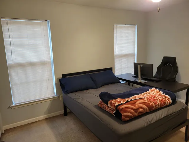 a bedroom with a large bed and a chandelier fan