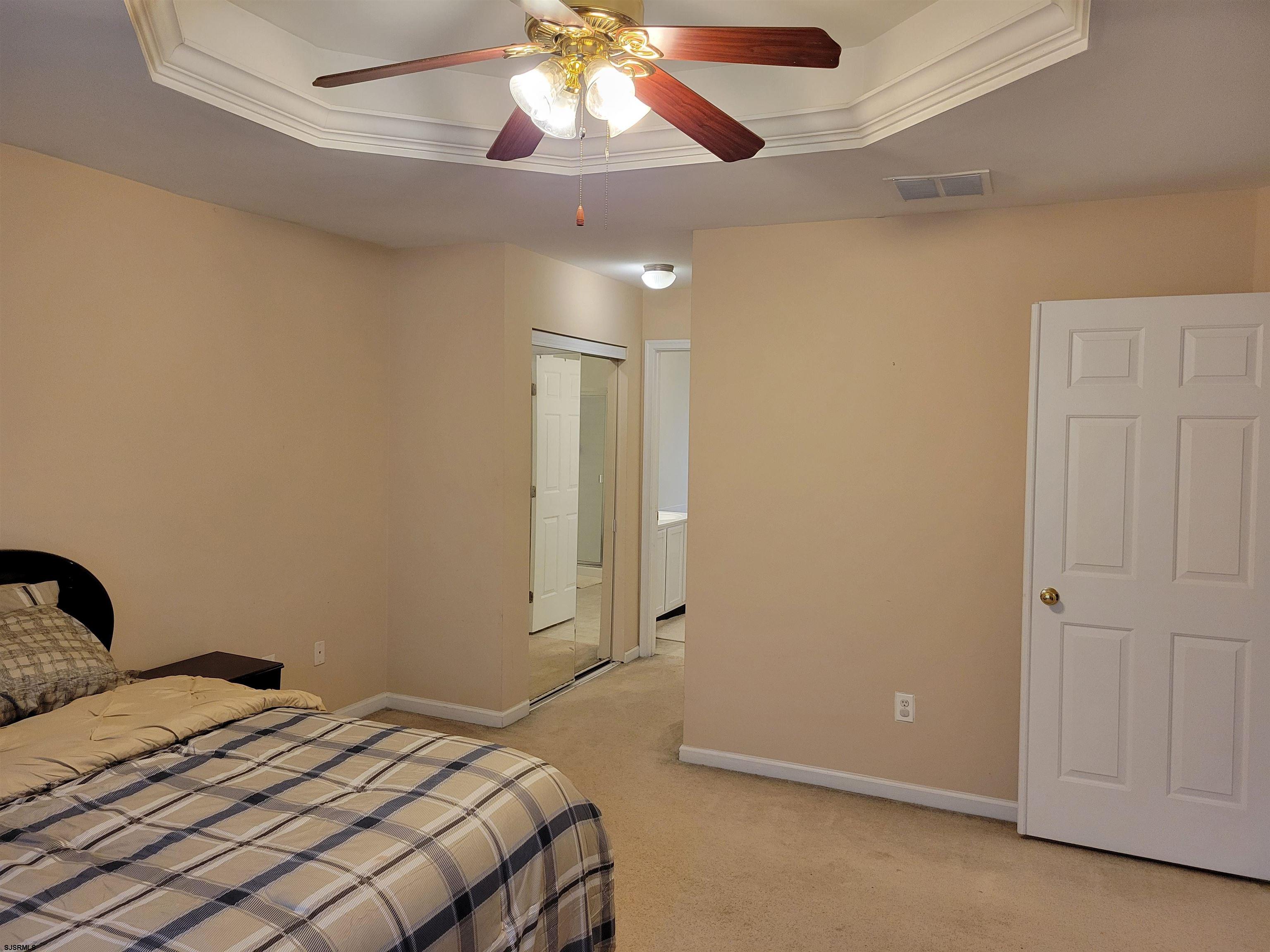 21 Sugarberry Road Egg Harbor Township, NJ 08234 - Photo 26 of 59 a bedroom with a large bed and a chandelier fan