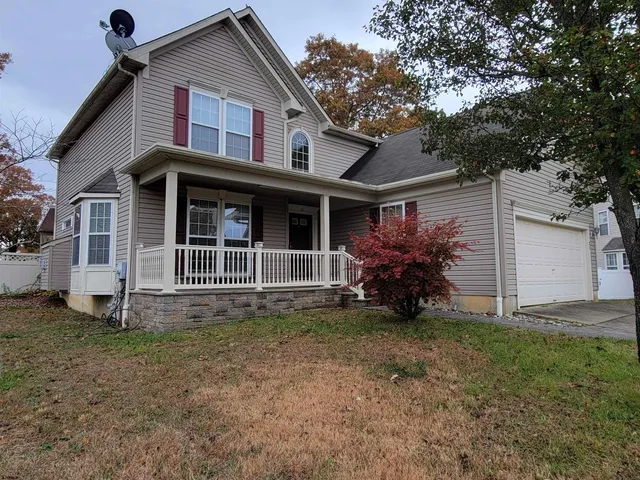 a view of a house with a yard and a large tree