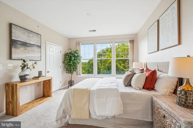 a bedroom with a bed and a large window