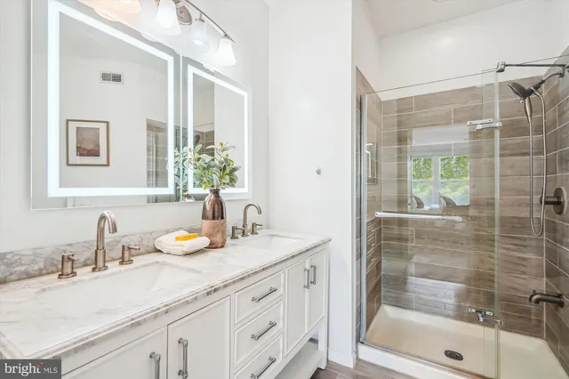 a bathroom with a sink and a mirror with bathtub
