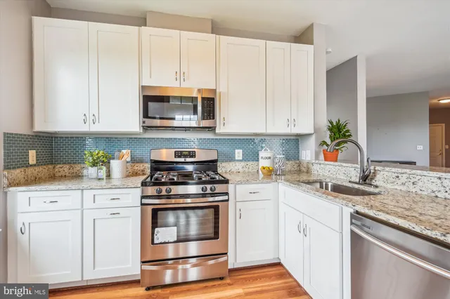 a kitchen with granite countertop white cabinets and white appliances