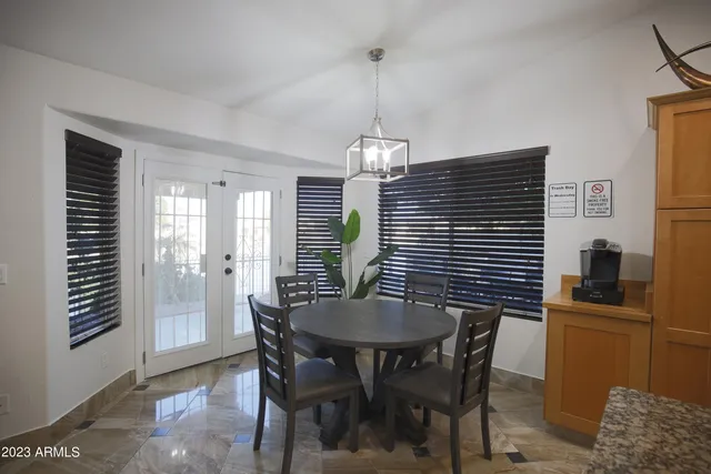 a kitchen with stainless steel appliances granite countertop a stove top oven a sink dishwasher a dining table and chairs with wooden floor