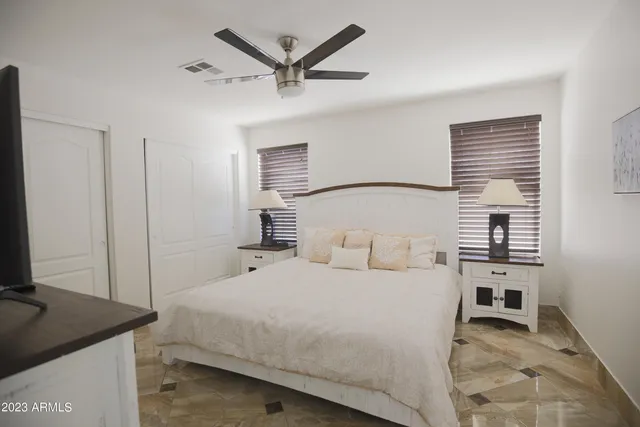 a large bed sitting in a bedroom next to a window