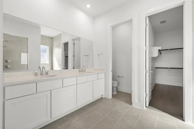 a spacious bathroom with a double vanity sink a mirror and a shower