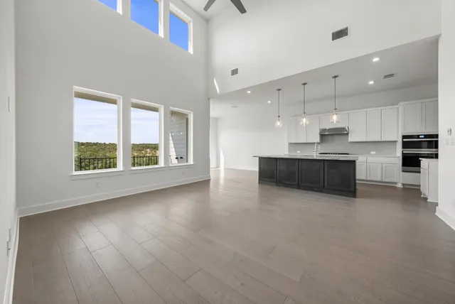 a large kitchen with stainless steel appliances granite countertop a stove a sink and a microwave