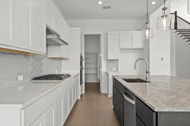 a kitchen with stainless steel appliances granite countertop a sink and cabinets