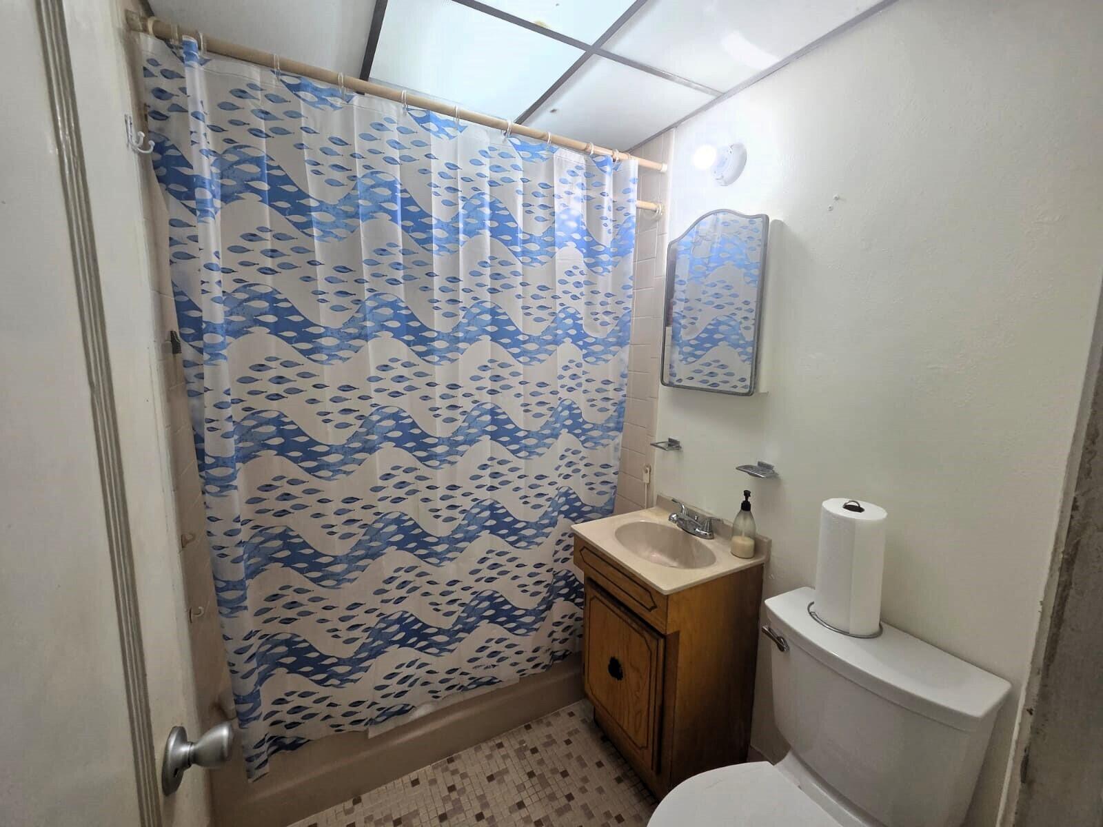 1060 West 26th Court Riviera Beach, FL 33404 - Photo 12 of 23 a bathroom with a toilet and a shower curtain