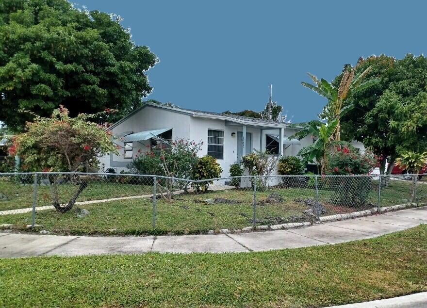 1060 West 26th Court Riviera Beach, FL 33404 - Photo 2 of 23 a front view of a house with a yard
