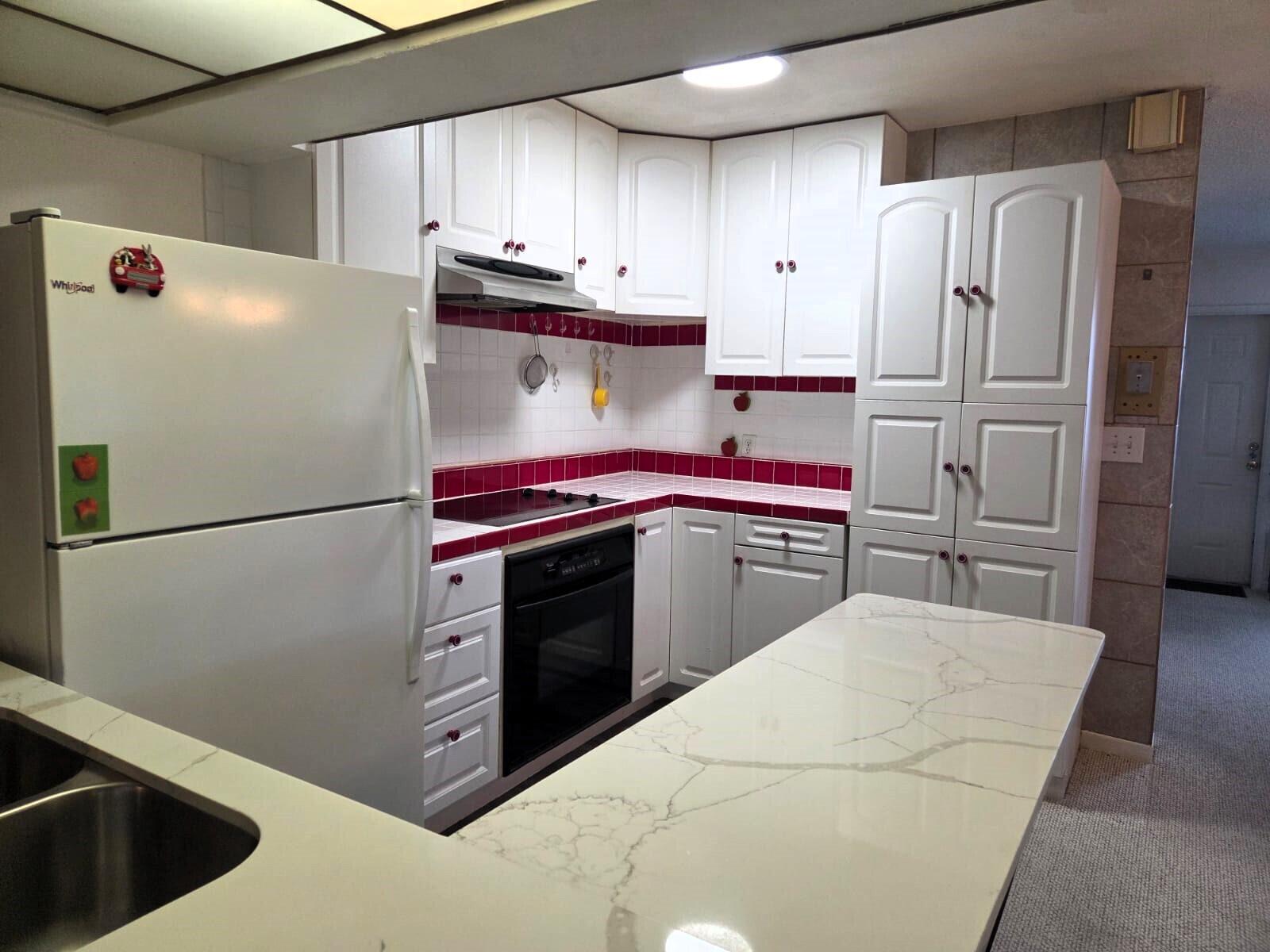 1060 West 26th Court Riviera Beach, FL 33404 - Photo 7 of 23 a kitchen with stainless steel appliances granite countertop a refrigerator sink and stove