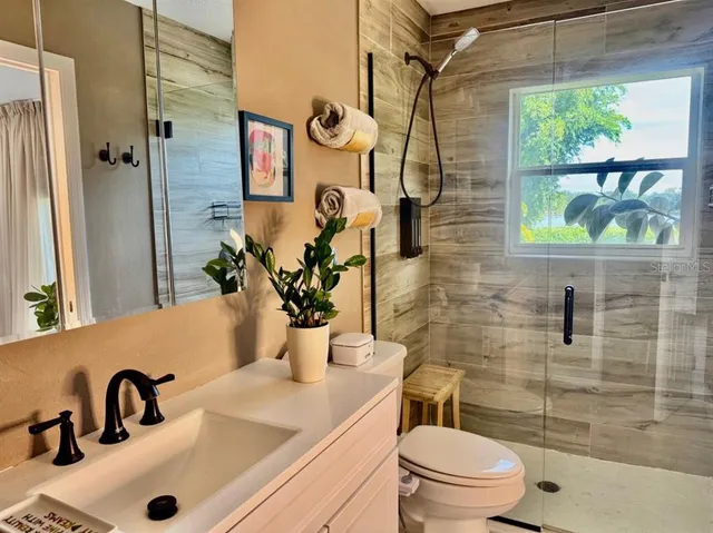 a bathroom with a sink a toilet and shower