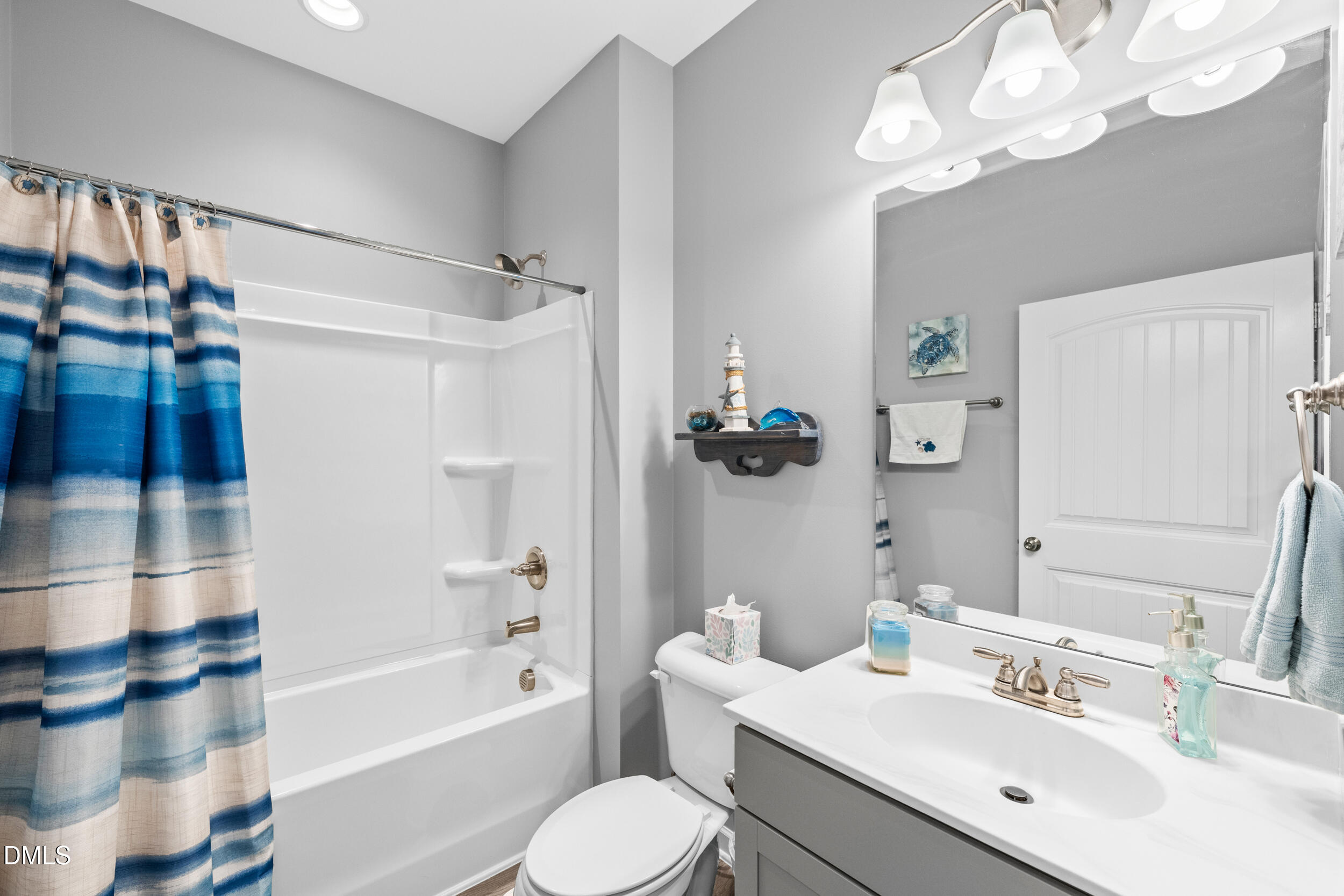 91 Charlottes Web Circle Benson, NC 27504 - Photo 17 of 29 a bathroom with a sink a toilet a mirror a bathtub and shower
