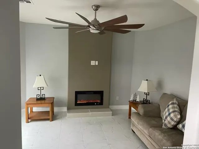 a living room with furniture a fireplace and a flat screen tv