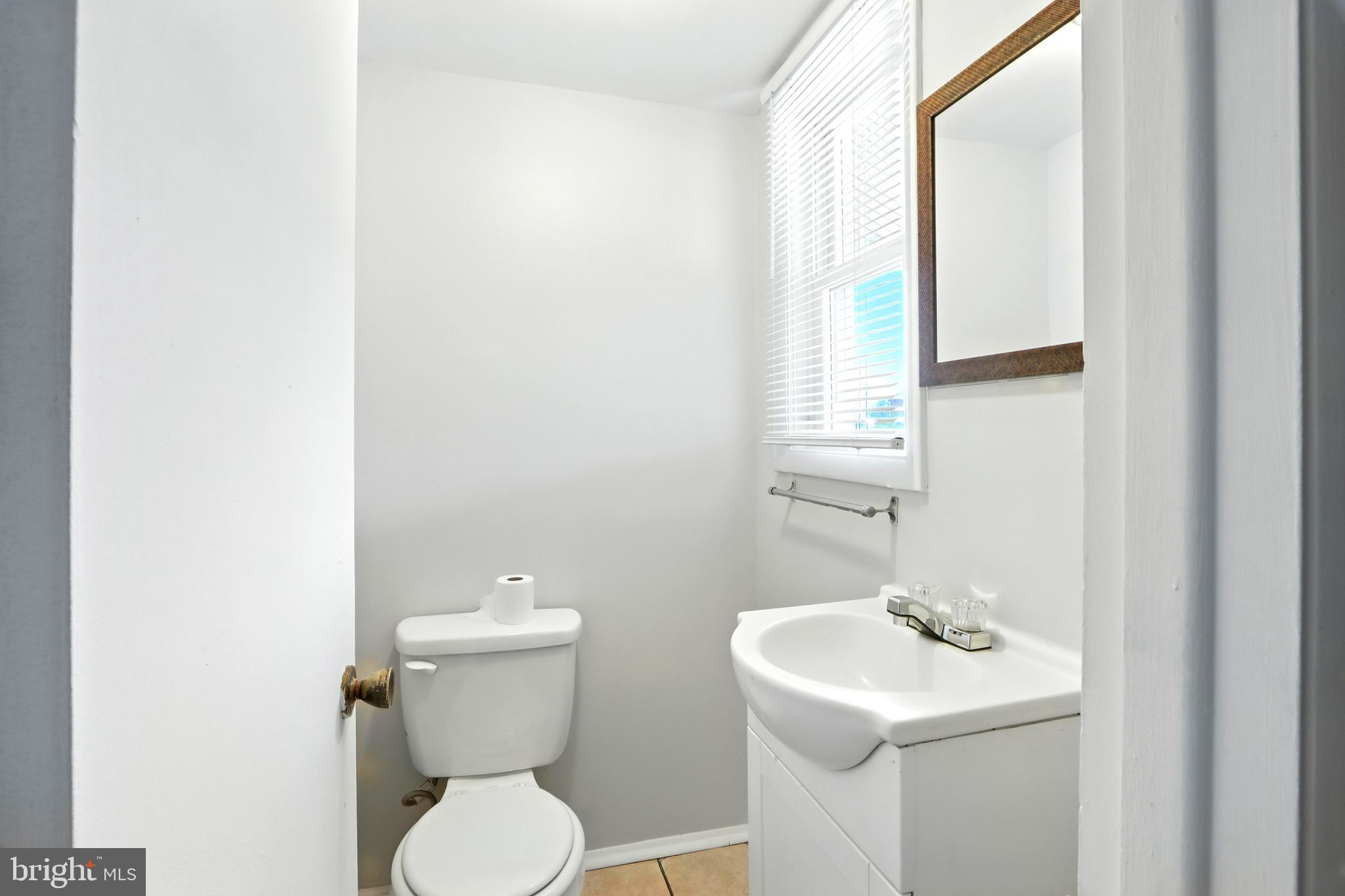 4255 Labyrinth Road Baltimore, MD 21215 - Photo 11 of 27 a bathroom with a toilet sink and mirror