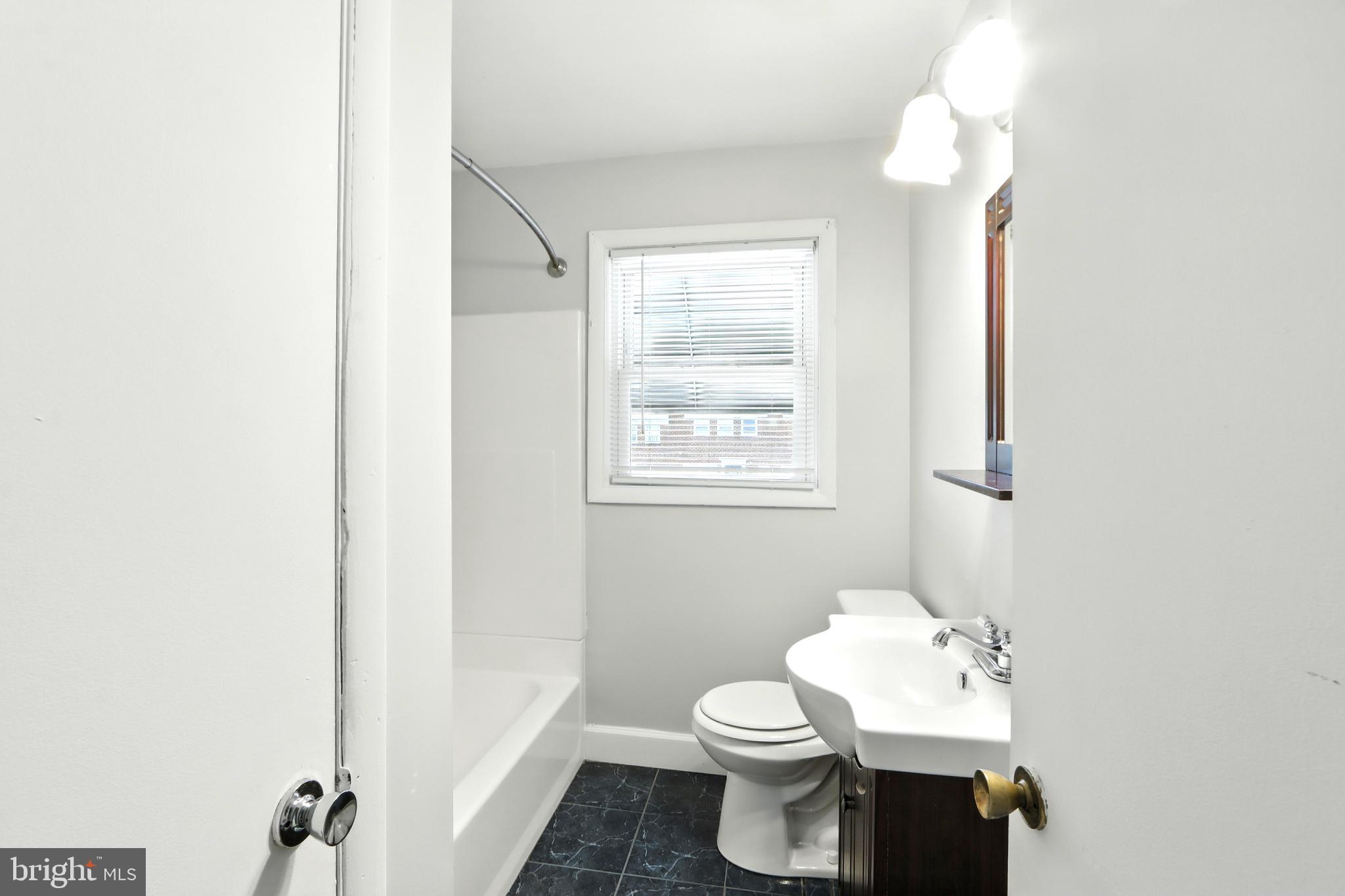 4255 Labyrinth Road Baltimore, MD 21215 - Photo 12 of 27 a white toilet sitting next to a bathroom sink
