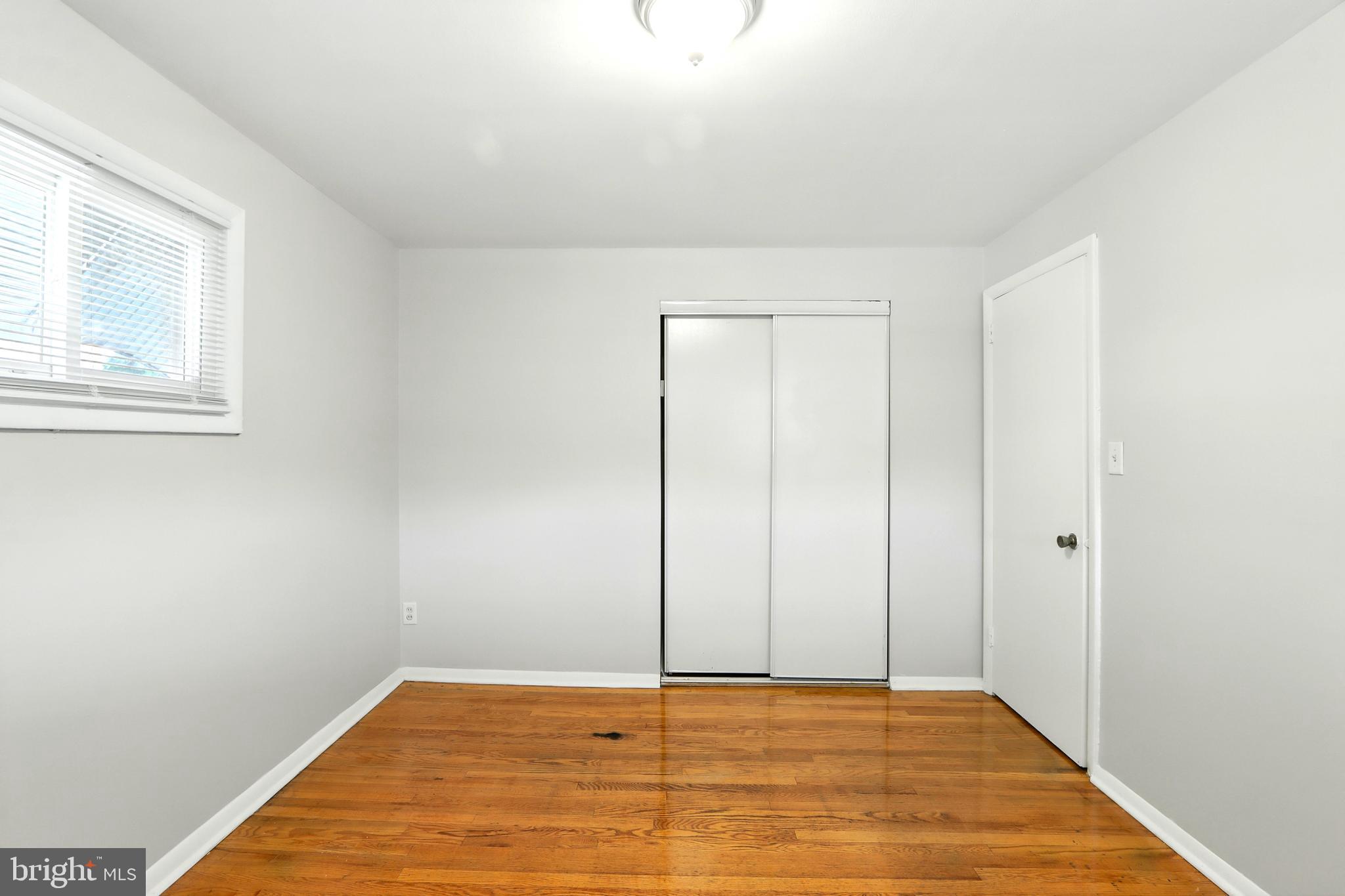 4255 Labyrinth Road Baltimore, MD 21215 - Photo 18 of 27 a view of an empty room with window and hardwood floor