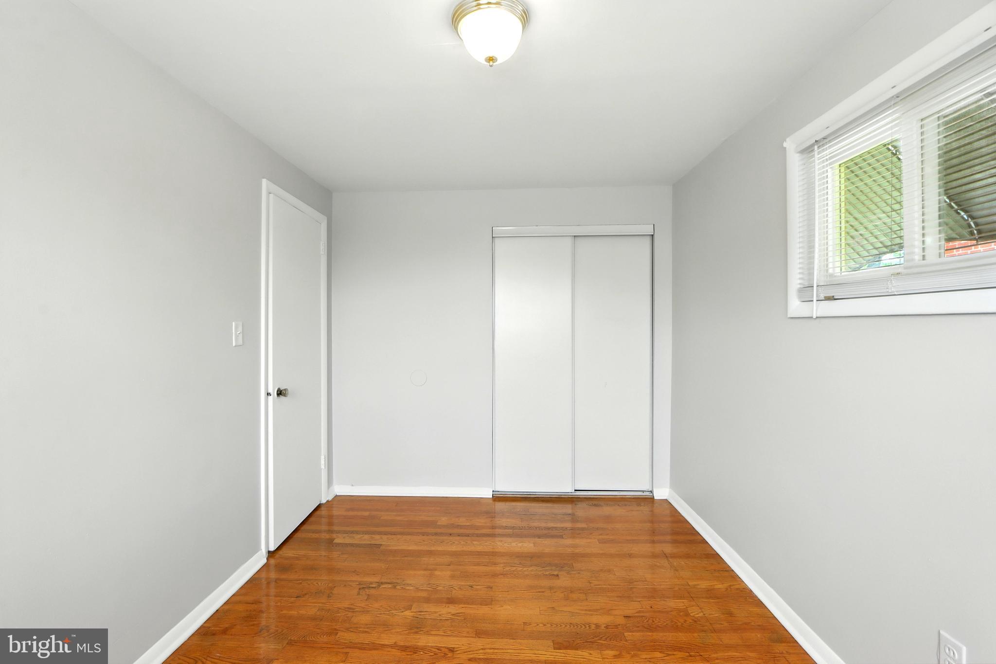 4255 Labyrinth Road Baltimore, MD 21215 - Photo 20 of 27 a view of an empty room with wooden floor and a window