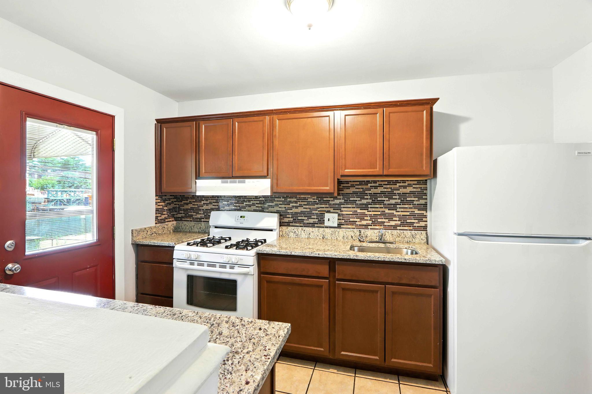 4255 Labyrinth Road Baltimore, MD 21215 - Photo 8 of 27 a kitchen with a stove a refrigerator and a sink