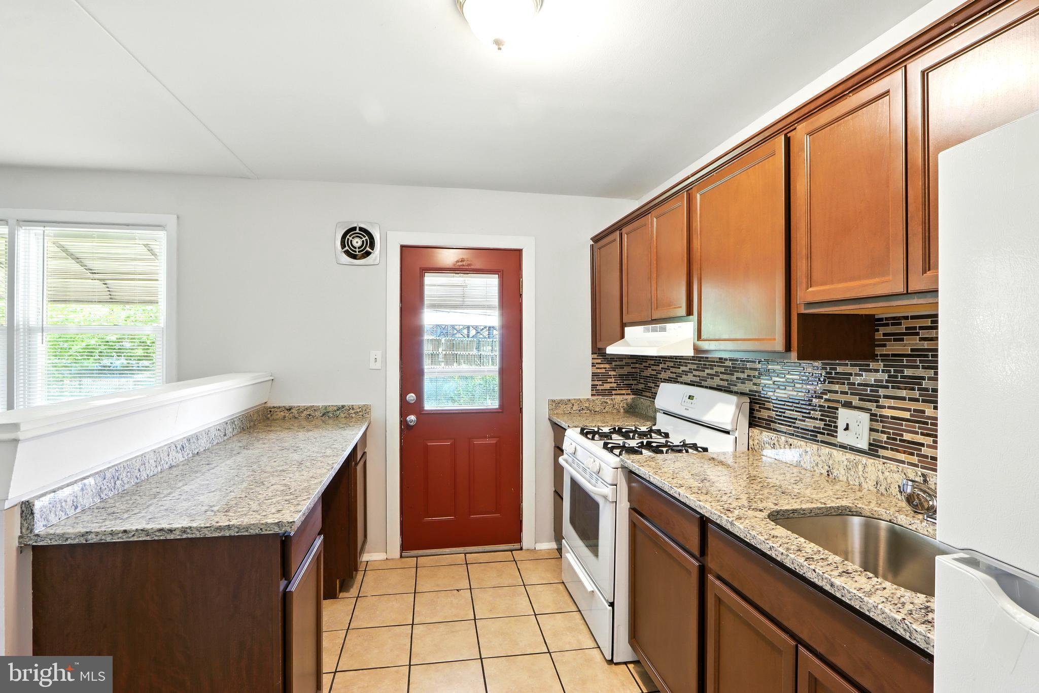 4255 Labyrinth Road Baltimore, MD 21215 - Photo 9 of 27 a kitchen with granite countertop a sink stove and cabinets