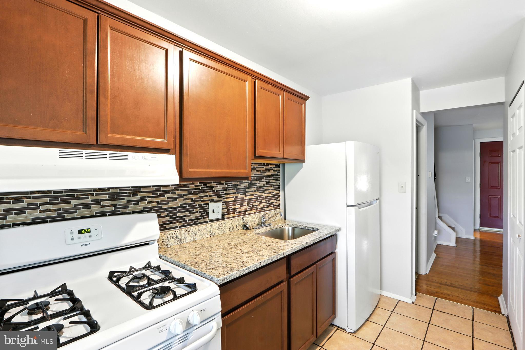 4255 Labyrinth Road Baltimore, MD 21215 - Photo 10 of 27 a kitchen with a stove a refrigerator and a sink