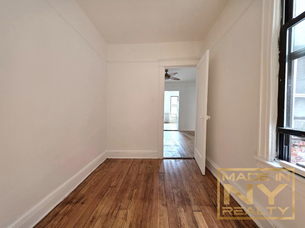 41-15 53rd Street, Unit E2 Queens, NY 11377 - Photo 2 of 7 wooden floor in an empty room with a window