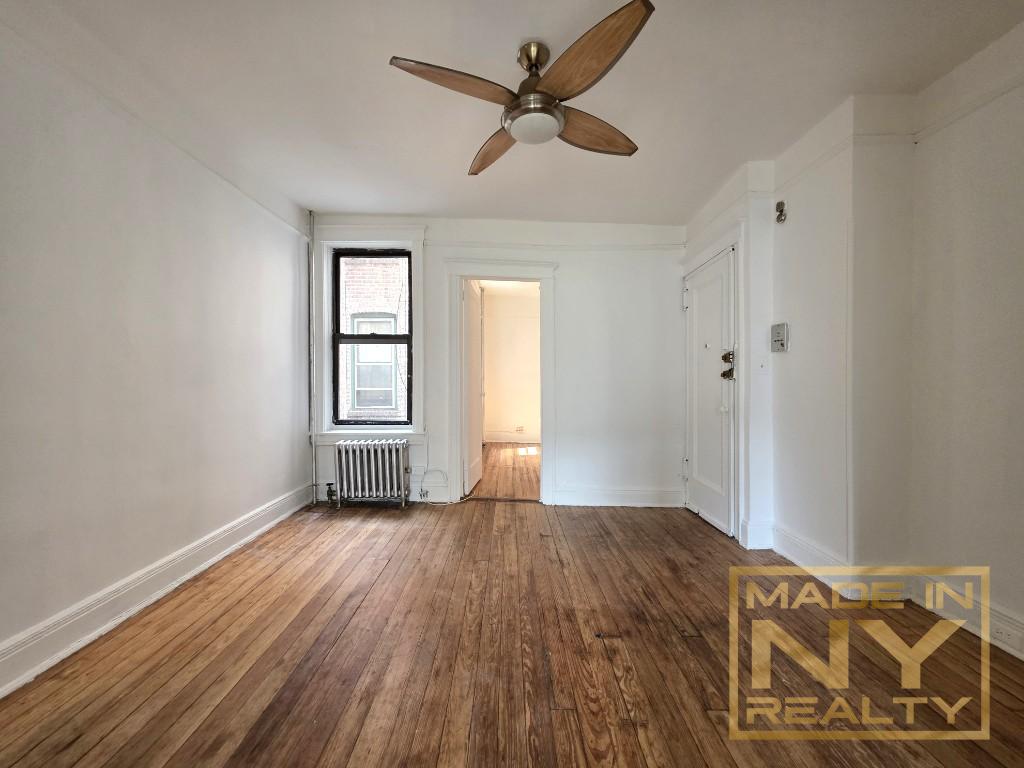 41-15 53rd Street, Unit E2 Queens, NY 11377 - Photo 3 of 7 wooden floor in an empty room with a window