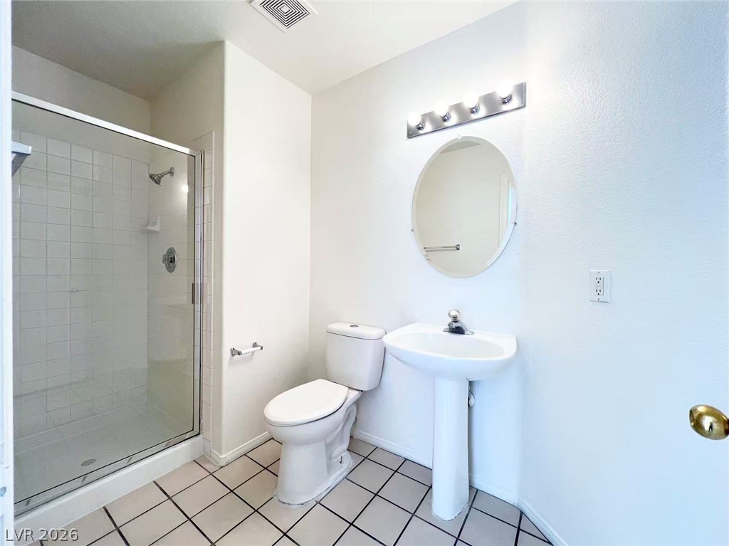 8284 West Rochelle Avenue Las Vegas, NV 89147 - Photo 12 of 29 A well-appointed bathroom features a glass-enclosed shower, a sleek pedestal sink, and tiled flooring.