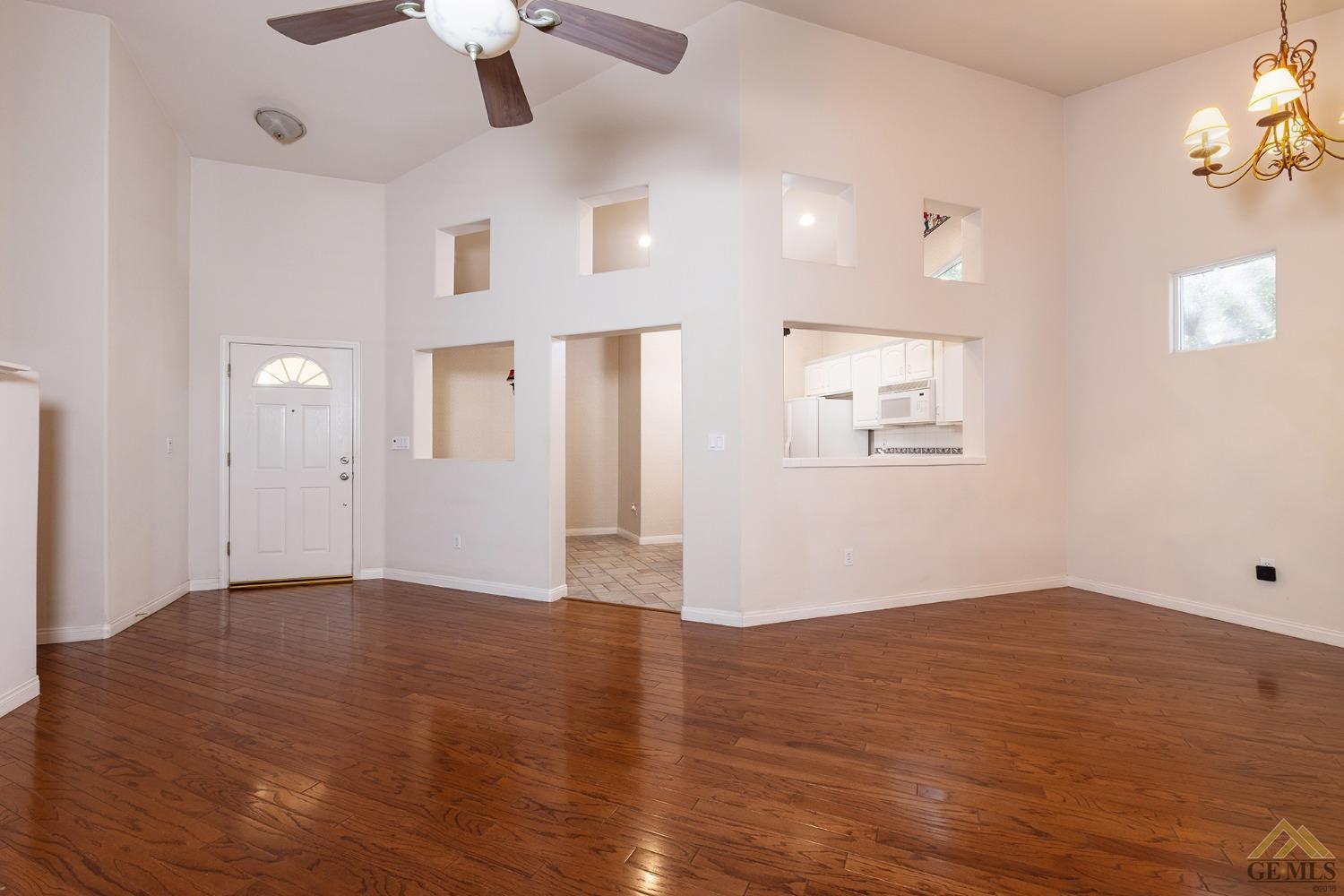 Undisclosed Address Bakersfield, CA 93311 - Photo 18 of 31 an empty room with wooden floor cabinet and windows