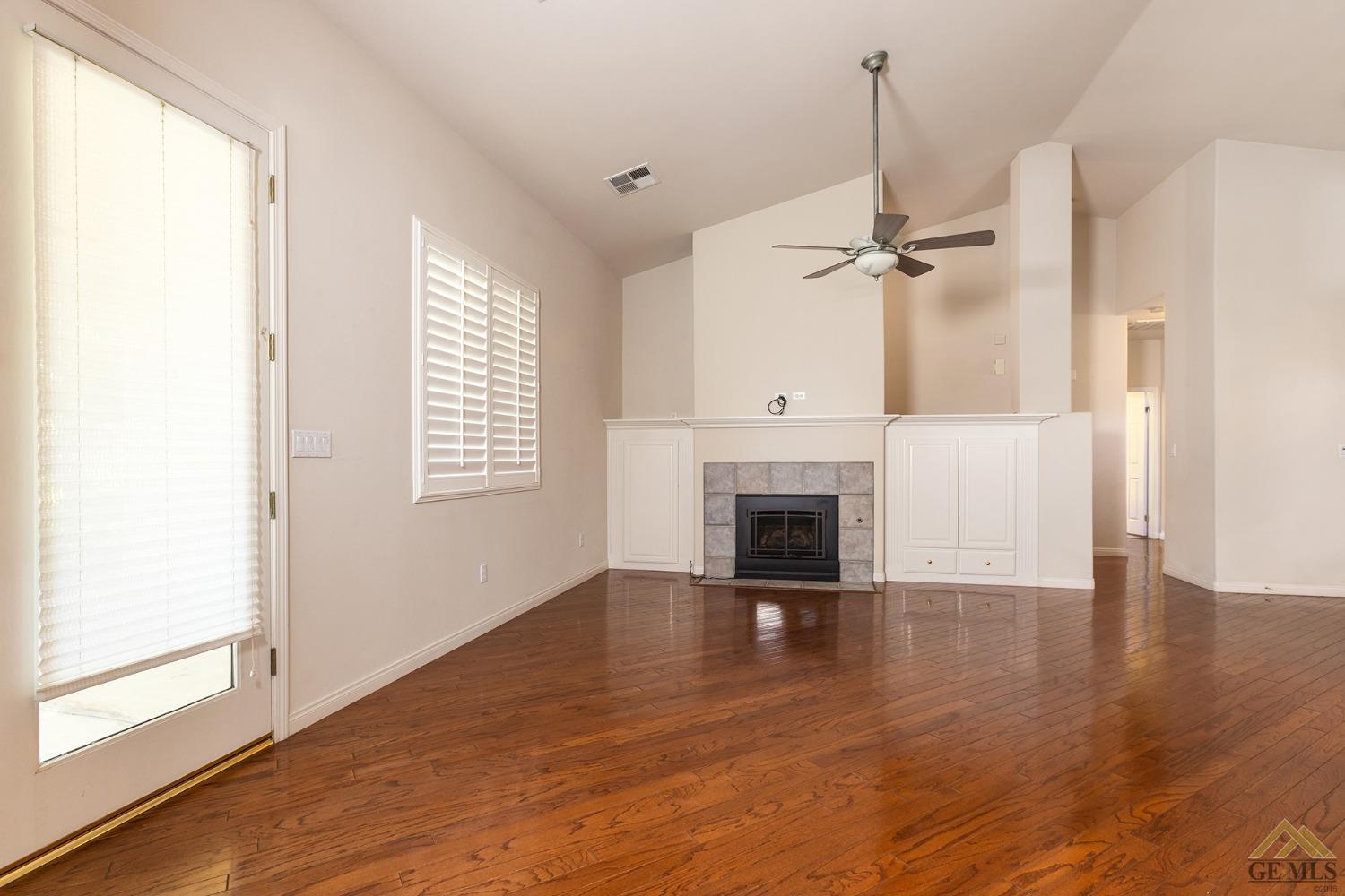 Undisclosed Address Bakersfield, CA 93311 - Photo 19 of 31 a view of empty room with a fireplace and wooden floor