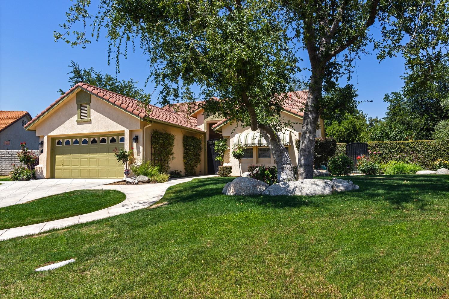 Undisclosed Address Bakersfield, CA 93311 - Photo 3 of 31 a front view of a house with a yard and garage