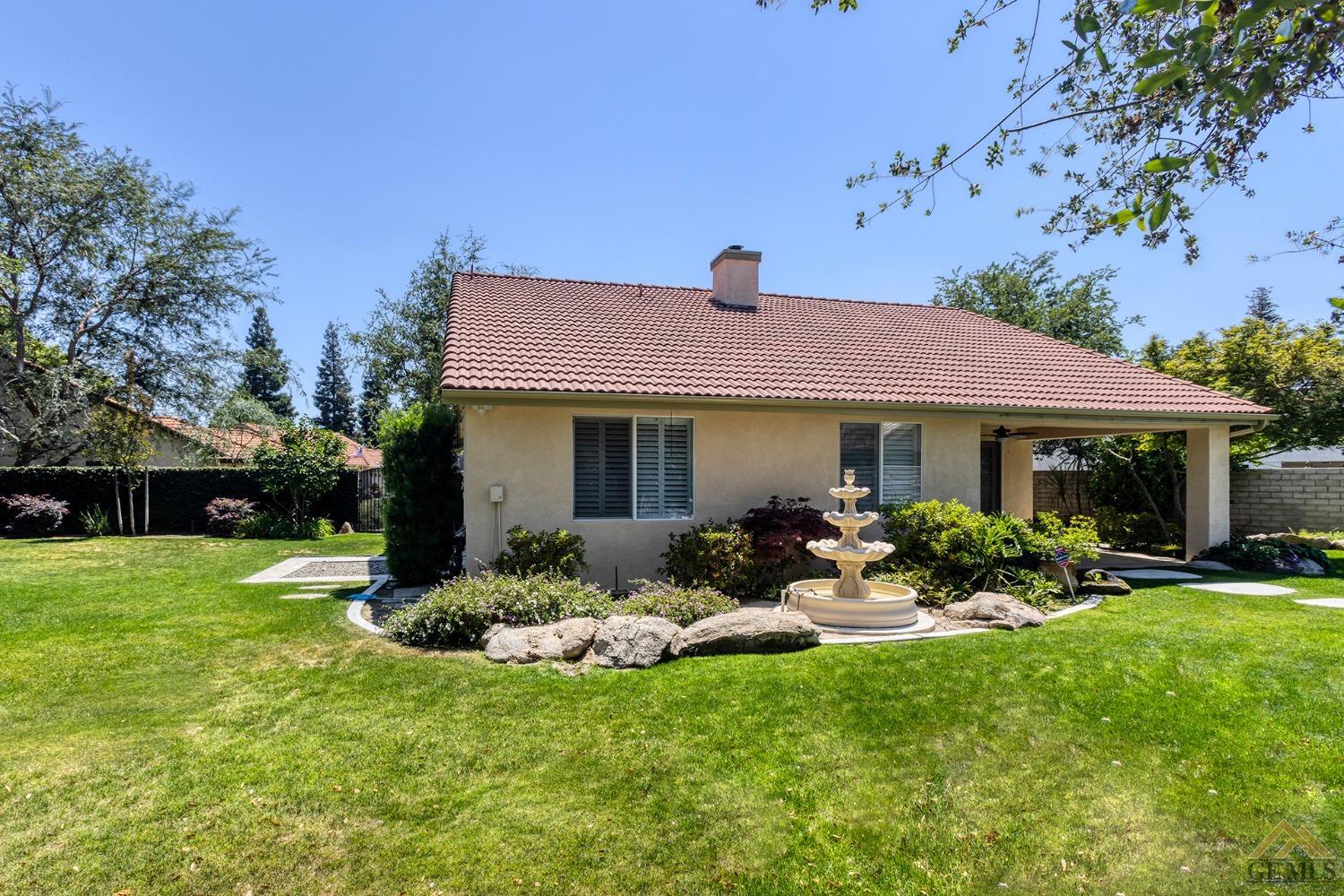 Undisclosed Address Bakersfield, CA 93311 - Photo 8 of 31 a front view of a house with a garden and porch