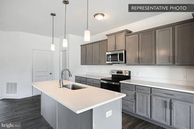 a kitchen with a sink a microwave and cabinets