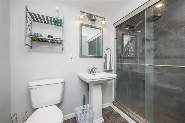 a bathroom with a sink mirror toilet and shower