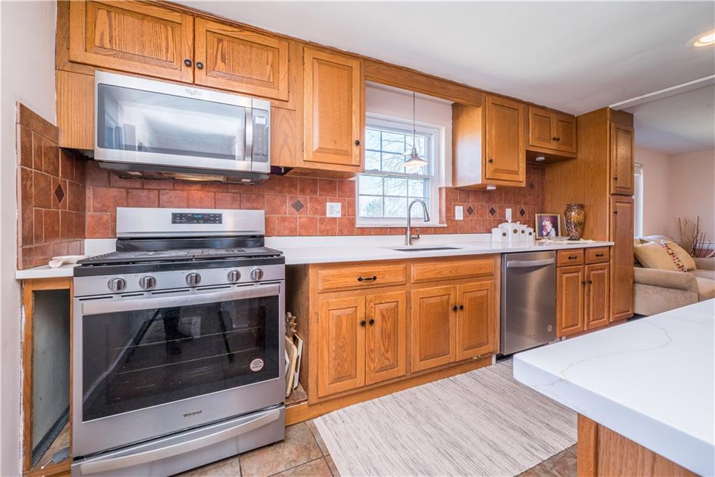 4915 Brownsville Road Pittsburgh, PA 15236 - Photo 7 of 21 a kitchen with stainless steel appliances a stove microwave and cabinets